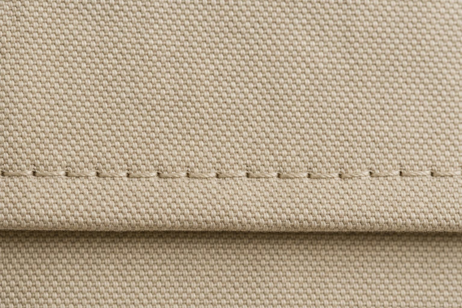 Macro of hem stitching at 12 stitches per centimetre on cotton canvas.